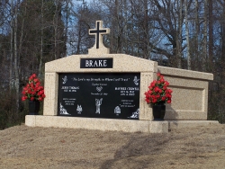 Side-by-side deluxe mausoleum with a cross, fluted columns, vases on pedestals in Pleasant Grove, AL