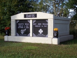 Side-by-side deluxe mausoleum with fluted columns and vases on pedestals