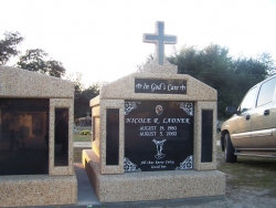 Single deluxe mausoleum with granite inlays in the columns and a cross on a foundation/slab in Pass Christian, MS