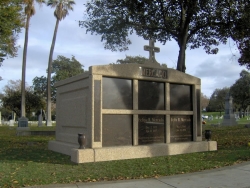 Six-space wide mausoleum with cross, granite inlays in the columns, turned vases on pedestals in San Jose, CA