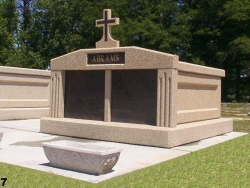 Side-by-side deluxe mausoleum with fluted columns and a cross on a slab