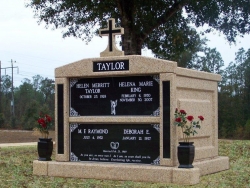 Four-space deluxe mausoleum with cross, granite inlays in the columns, vases on pedestals in Diamondhead, MS