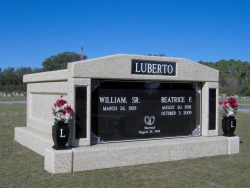 Side-by-side deluxe mausoleum with granite inlays in the columns and vases on pedestals in Eastpoint, FL