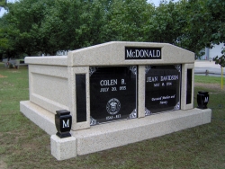 Side-by-side deluxe mausoleum with granite inlays in the columns and vases on pedestals in Bonaire, GA