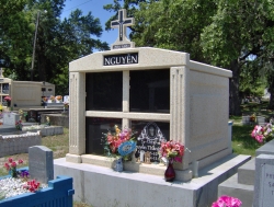 Four-space deluxe mausoleum with cross and fluted columns on a very high foundation in Biloxi, MS