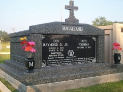 Side-by-side deluxe mausoleum deep gray with cross, fluted columns, vases on pedestals, step-up trim pieces on a foundation/slab in Pascagoula, MS