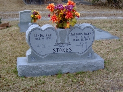 Double upright headstone with two hearts and a vase on a base