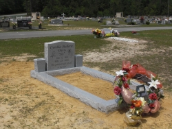 Single granite upright headstone with 2 vases and matching granite coping in Vancleave, MS