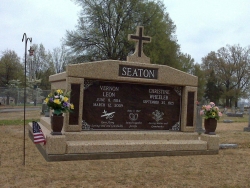 Side-by-side deluxe mausoleum with cross, granite inlays in the columns, vases and pedestals, step-up trim pieces on a foundation/slab in Dyersburg, TN