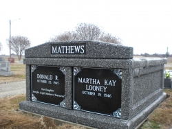 We deliver in the cold winter in January. There is ice on the top of this beautiful side-by-side basic mausoleum in deep gray with a header piece and split doors on a foundation/slab in Walnut Ridge, AR