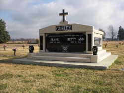 Side-by-side deluxe mausoleum with cross and granite in the columns, vases on pedestals, engraved wide panels and step-up trim pieces on a foundation/slab in Clarksdale, MS