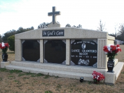 Three-space wide mausoleum with fluted columns on a foundation, vases on pedestals and step-up trim pieces in Hartsville, SC